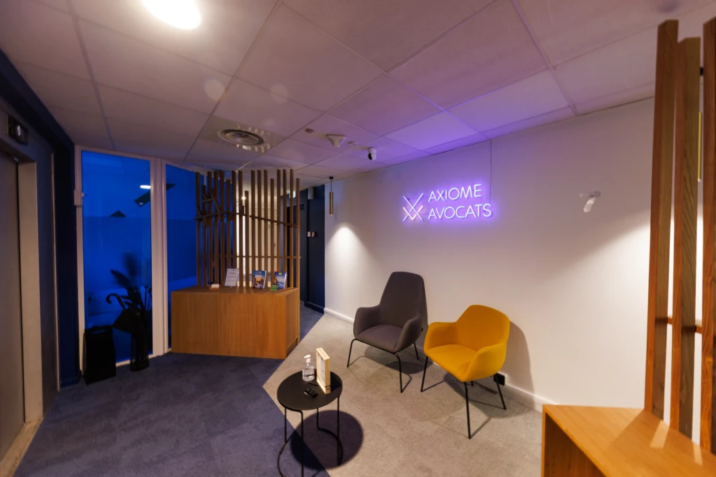 Espace d’accueil du cabinet Axiome Avocats avec fauteuils et enseigne lumineuse